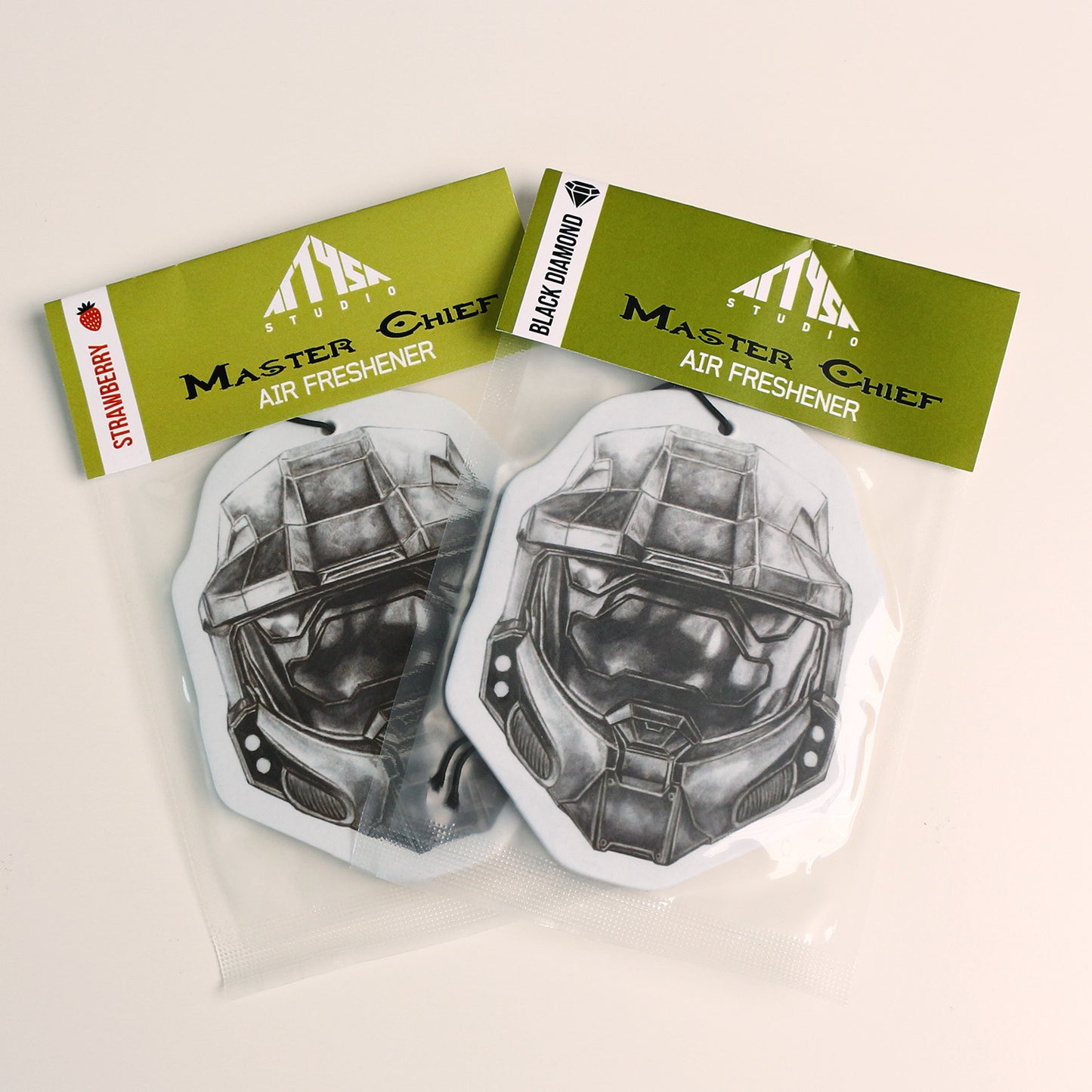 Packaged Master Chief Halo‑themed air freshener sealed with elastic tie, available in Strawberry and Black Diamond scent.