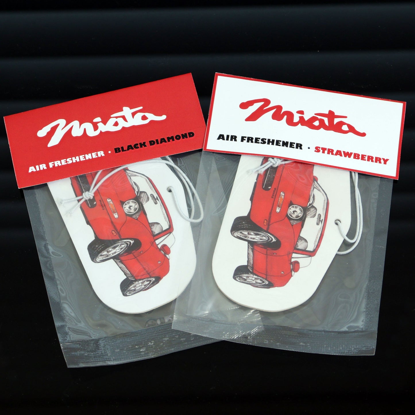Mazda Miata MX5 Air Freshener, measures: H: 5.5cm, W: 10cm. Each air freshener comes sealed and each includes an elastic tie. Available in Black Diamond & Strawberry scents, perfect for JDM fans & automotive art lovers.