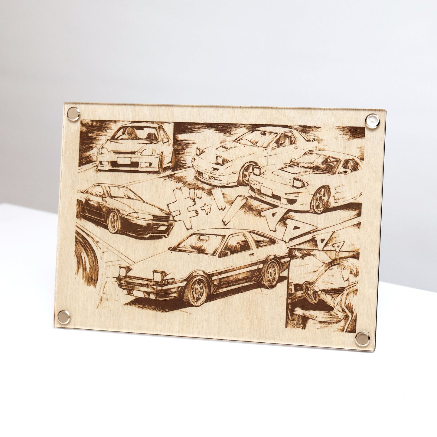 Unique wooden laser-engraved plaque inspired by Initial D. LayaBoard Art Initial D JDM Collage displayed on table with engraved images of Fujiwara’s AE86, Nakazato’s Skyline R32 GT-R, the Takahashi brothers’ RX-7s, and Shoji’s Civic. Encased in trademarked LayaBoard frame, this piece blends timeless aesthetics with a sleek, minimalist design.