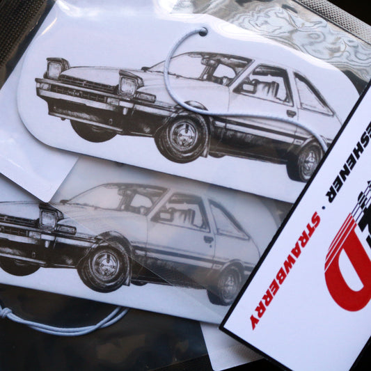 This Initial D AE86 air freshener card strawberry scent is ideal for decorating your car and keep the air fresh. Measures: H: 5cm, W: 11cm. We currently stock Black Ice or Strawberry scent. Each air freshener comes sealed and each includes an elastic.