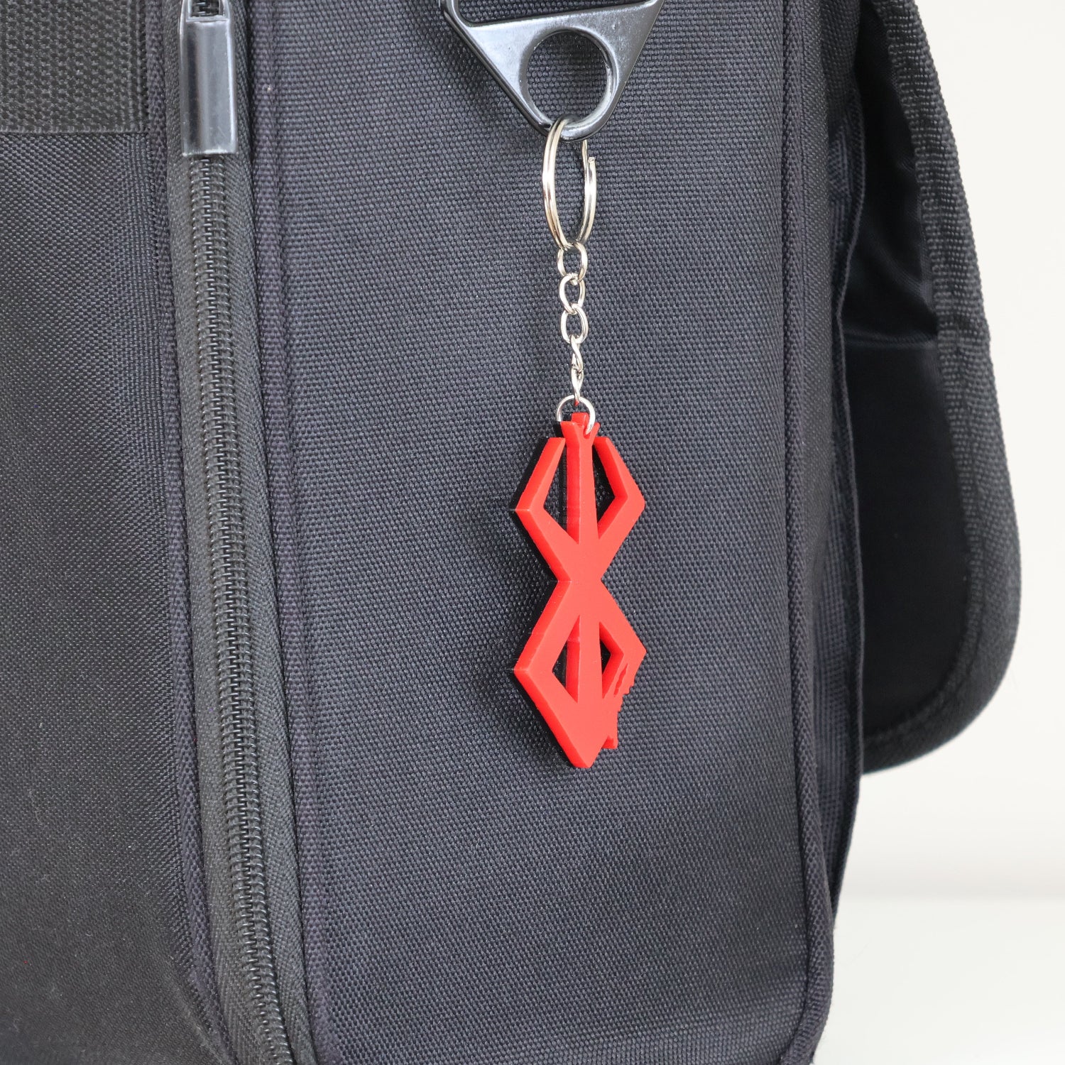 Berserk Brand of Sacrifice Keyring/keychain attached to a black colour shoulder bag.