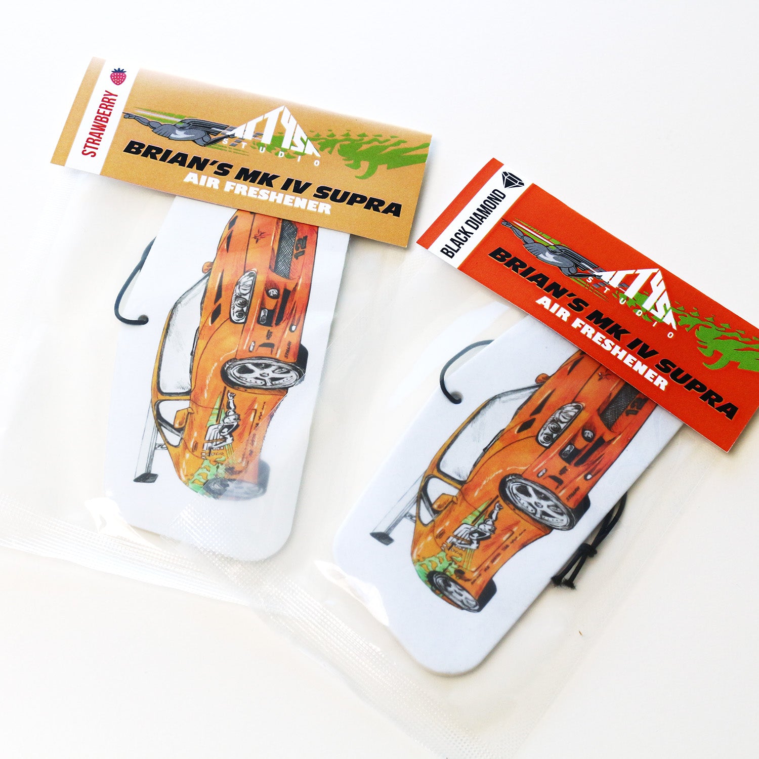 Packaged MK4 Supra air freshener with orange Supra illustration and elastic tie.