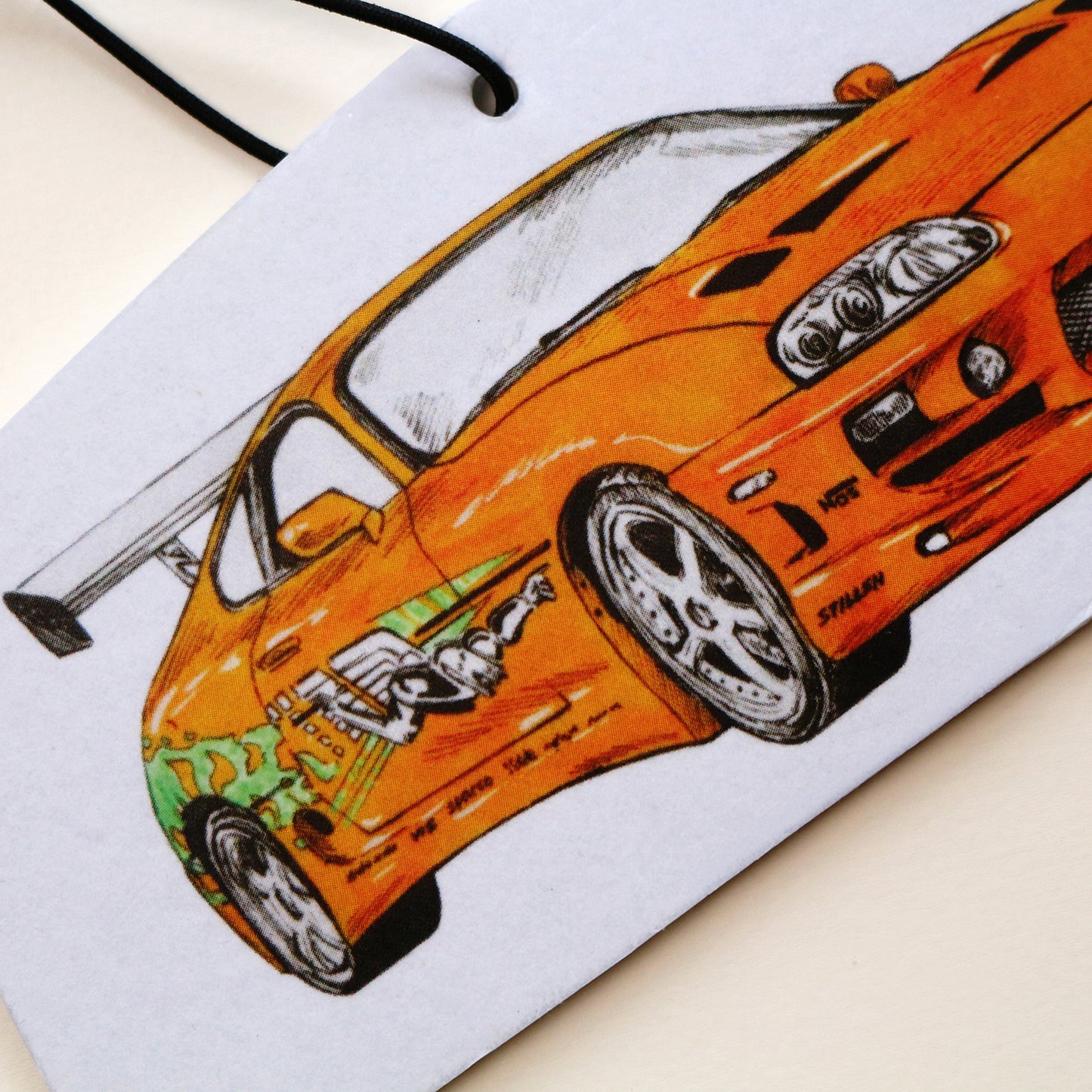 Close‑up of Brian’s MK4 Supra air freshener showing detailed orange body and rear end artwork.