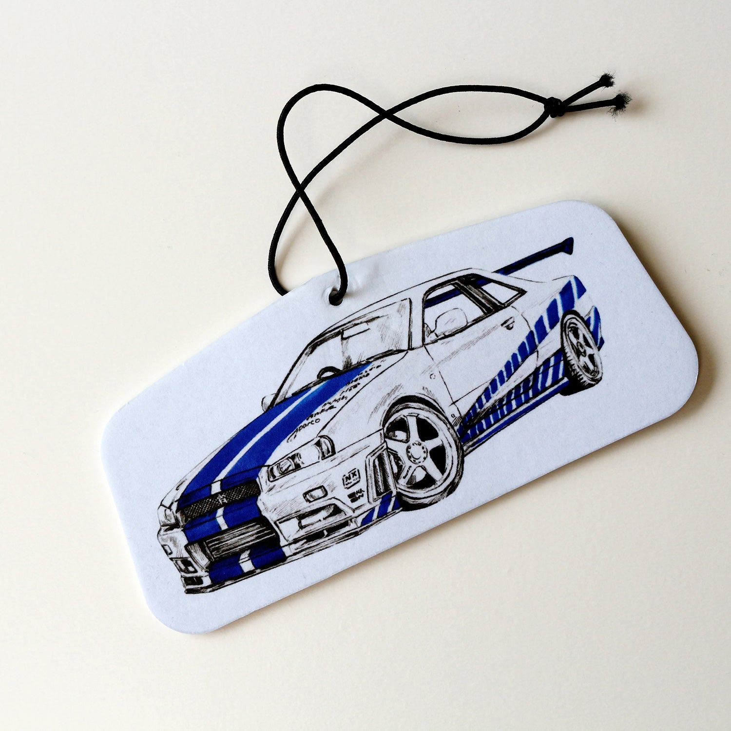 Hand‑drawn Brian’s Nissan Skyline R34 GT‑R air freshener in blue, front view.
