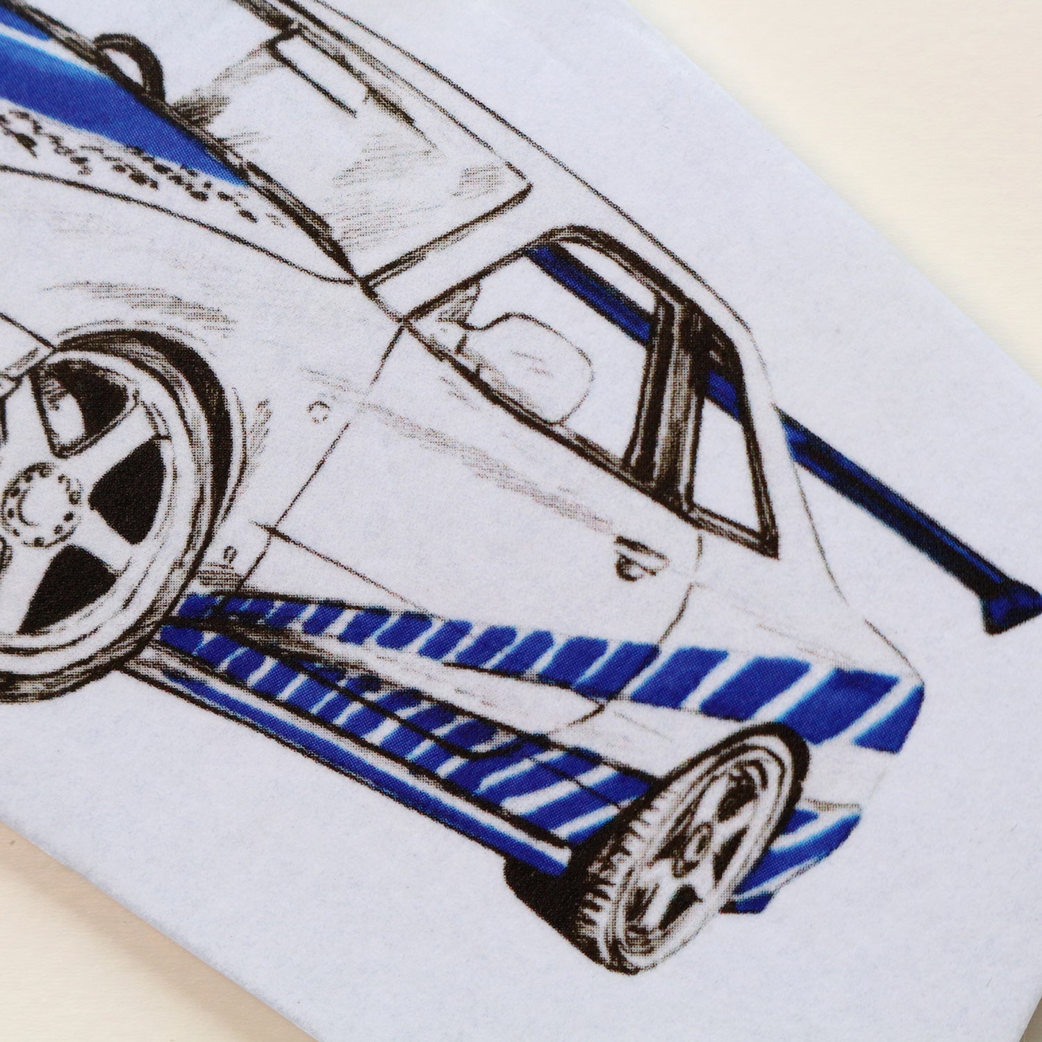 Close‑up of Brian’s R34 GT‑R air freshener showing rear end detailed blue Skyline artwork.