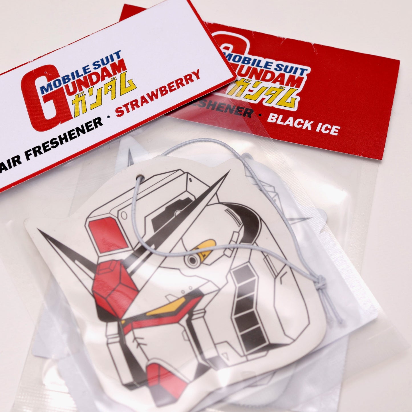 Gundam car air freshener card measures: H: 10cm x W: 9cm. Currently stock Black Ice or Strawberry scent. Each air freshener comes sealed and includes an elastic tie for easy placement.