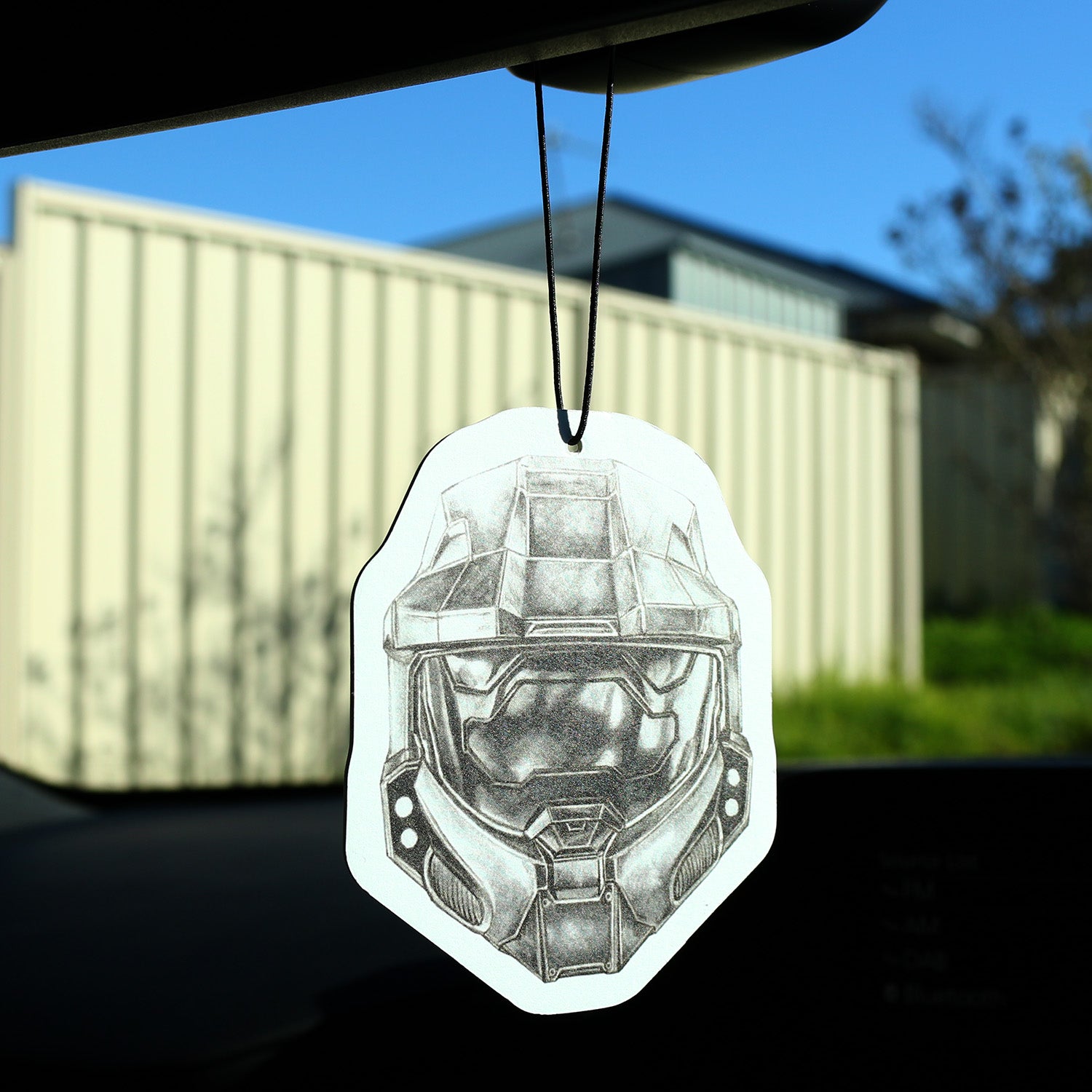 Master Chief car air freshener hanging from rear‑view mirror inside vehicle.
