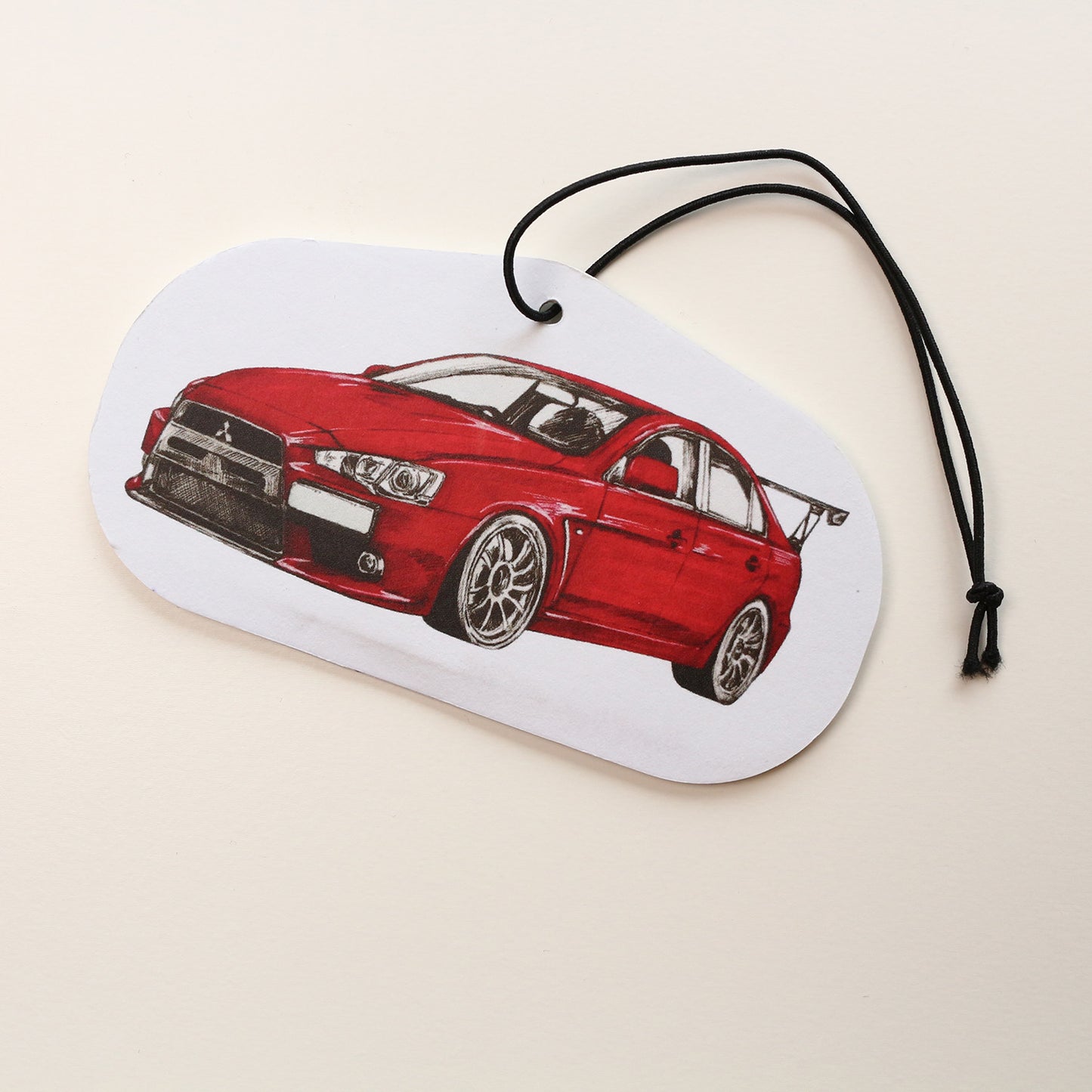 Hand‑drawn red colour Mitsubishi Lancer EVO X air freshener showing detailed hand‑drawn artwork, front view.