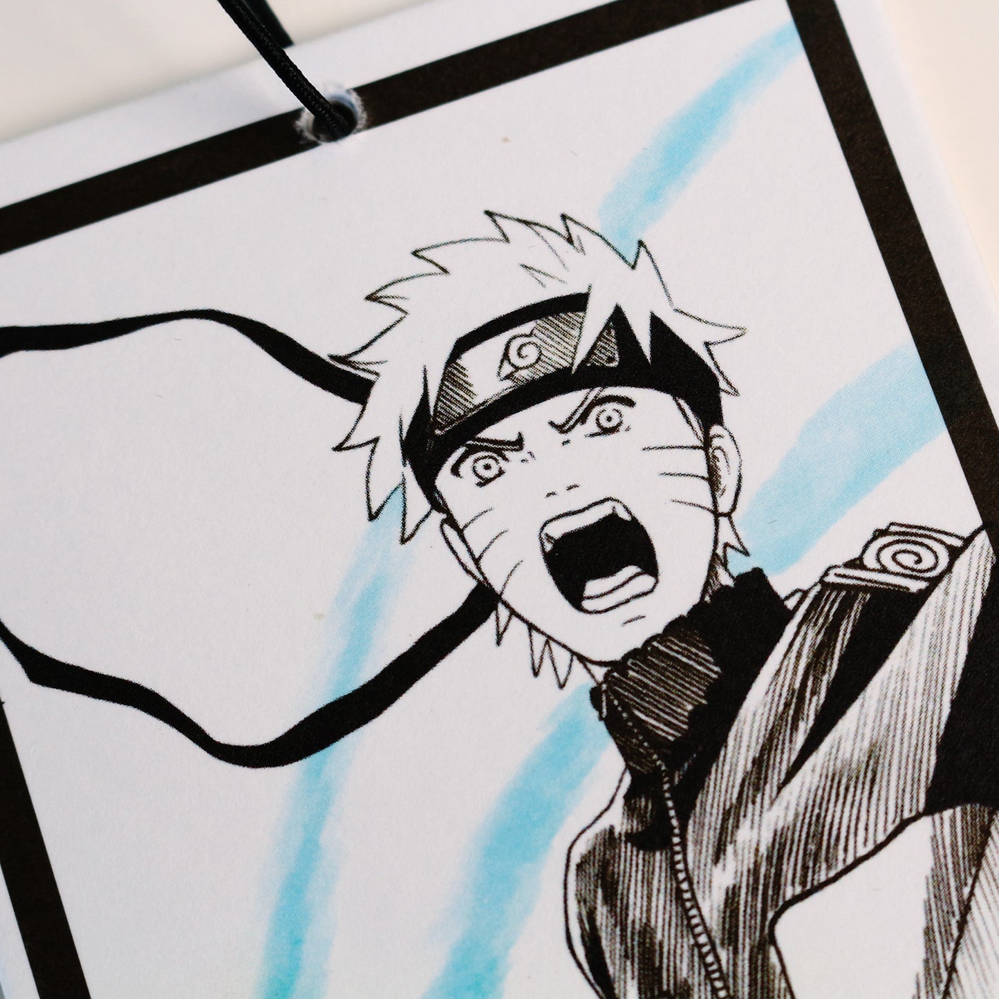 Close‑up of Naruto manga artwork on scented car freshener
