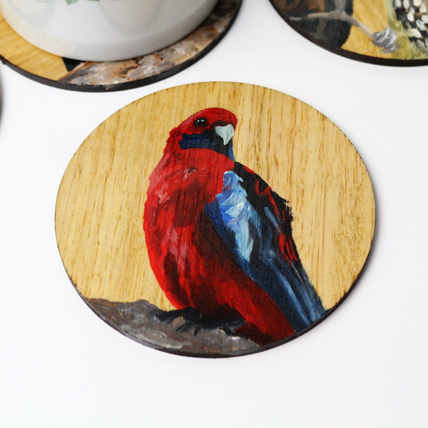 Artysn Studio's crimson rosella wooden coaster makes the perfect gift for any bird lover or a perfect addition to enhance your home decor and showcase your passion for Australia's diverse wildlife. Individually hand-painted by artist using acrylic paints on Eucalyptus wood.