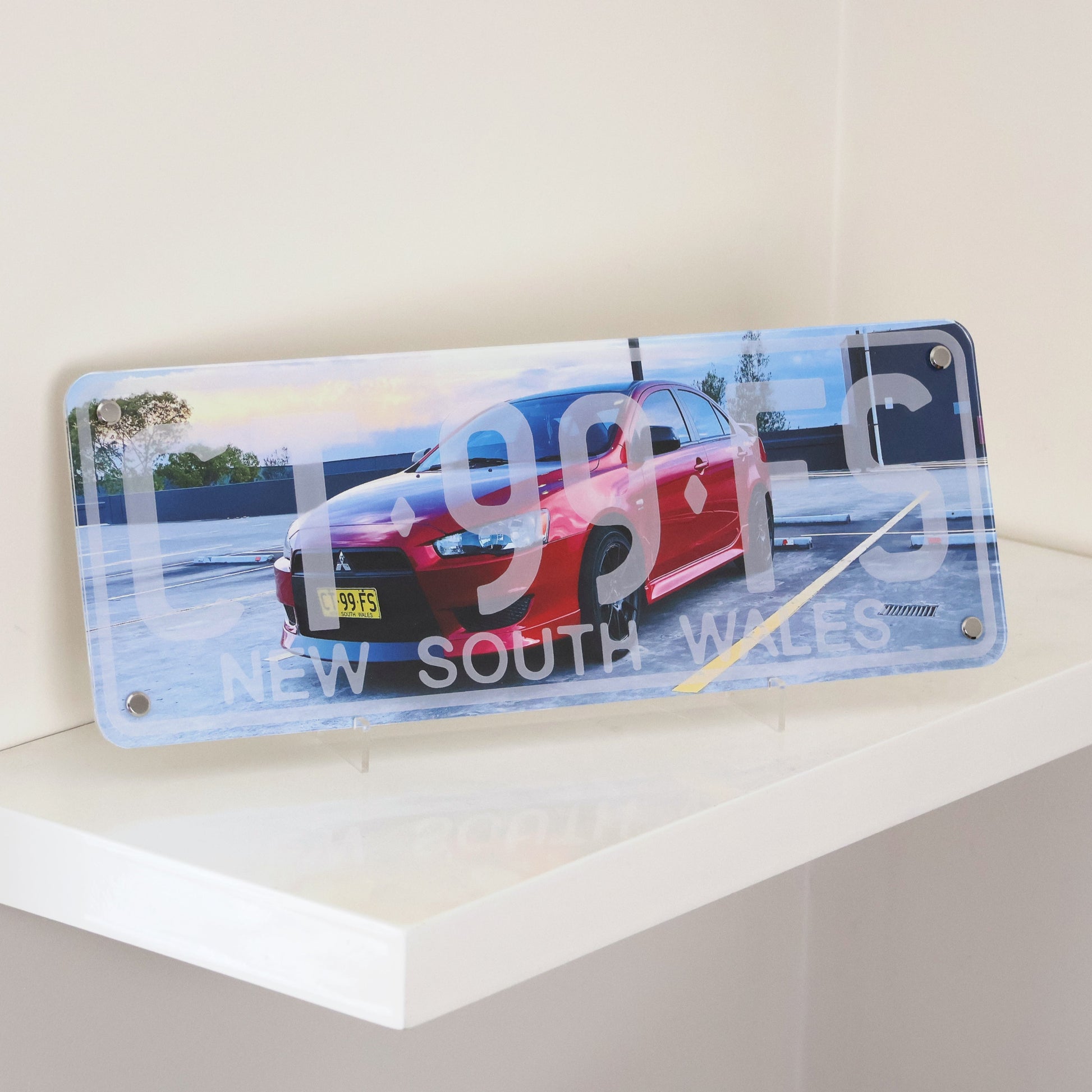 Custom car number plate wall decor displayed on shelf.