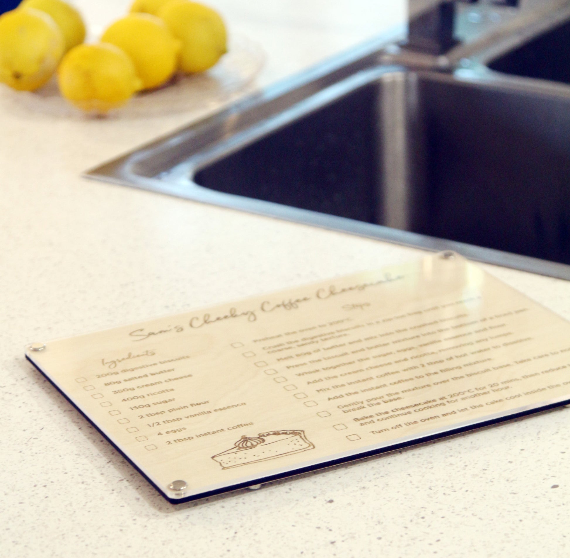 Custom engraved Recipe LayaBoard with acrylic dry‑erase surface for displaying family recipes displayed next to the kitchen sink.
