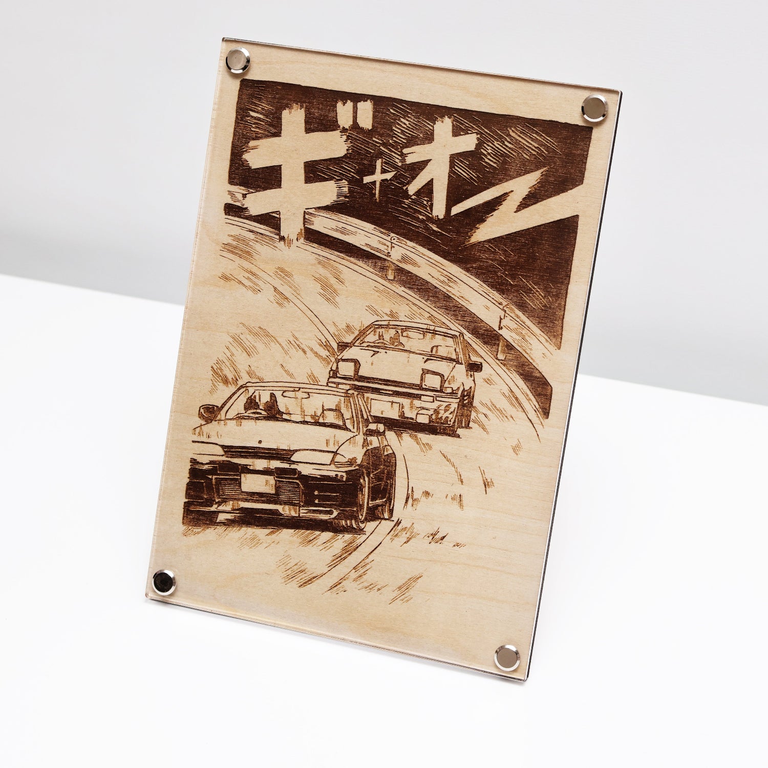 JDM car culture artwork created with LayaBoard Art system. This picture showing a laser engraved artwork of GTR R32 racing AE86 in manga style on a desk.