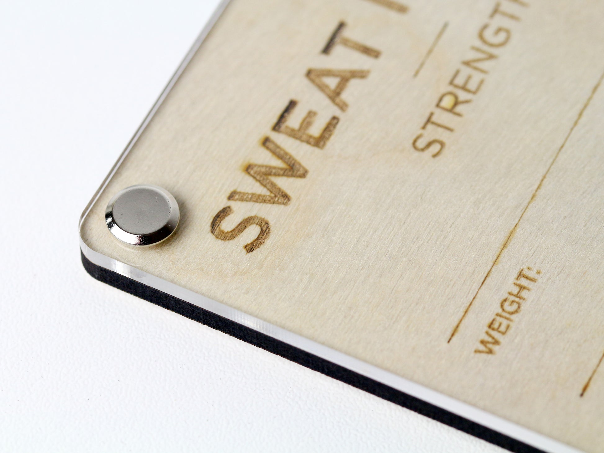 Top corner close-up of custom Gym Workout LayaBoard with acrylic dry‑erase surface for tracking strength and cardio exercises.