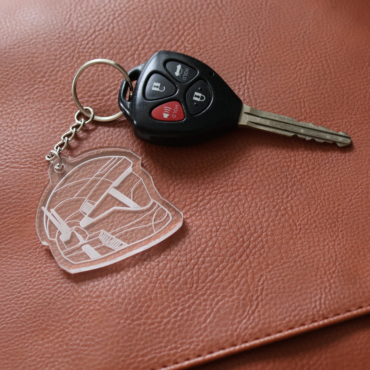 Keychain with Halo ODST helmet design and key on a brown leather surface
