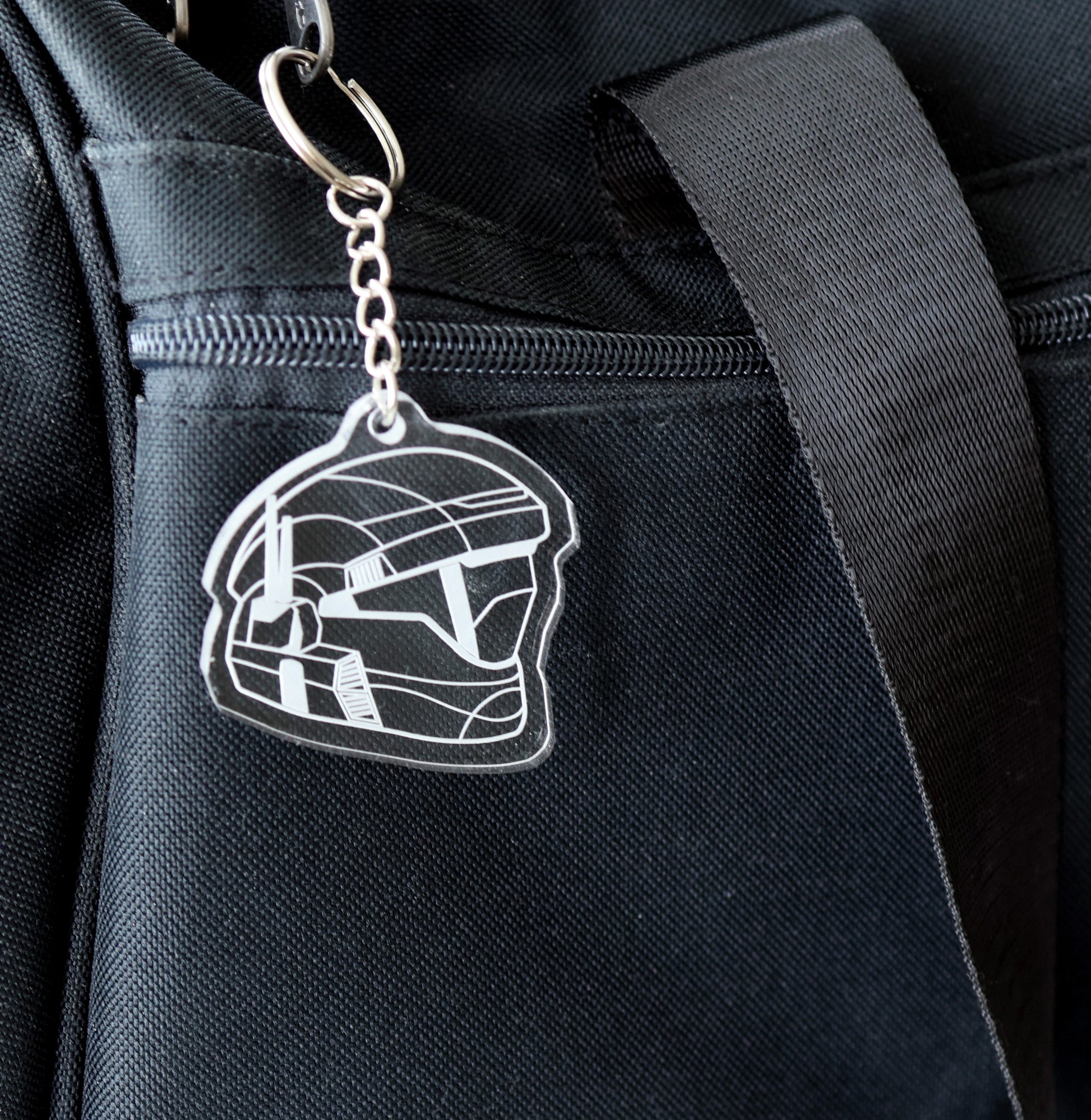 Keychain with halo ODST helmet design attached to a black bag