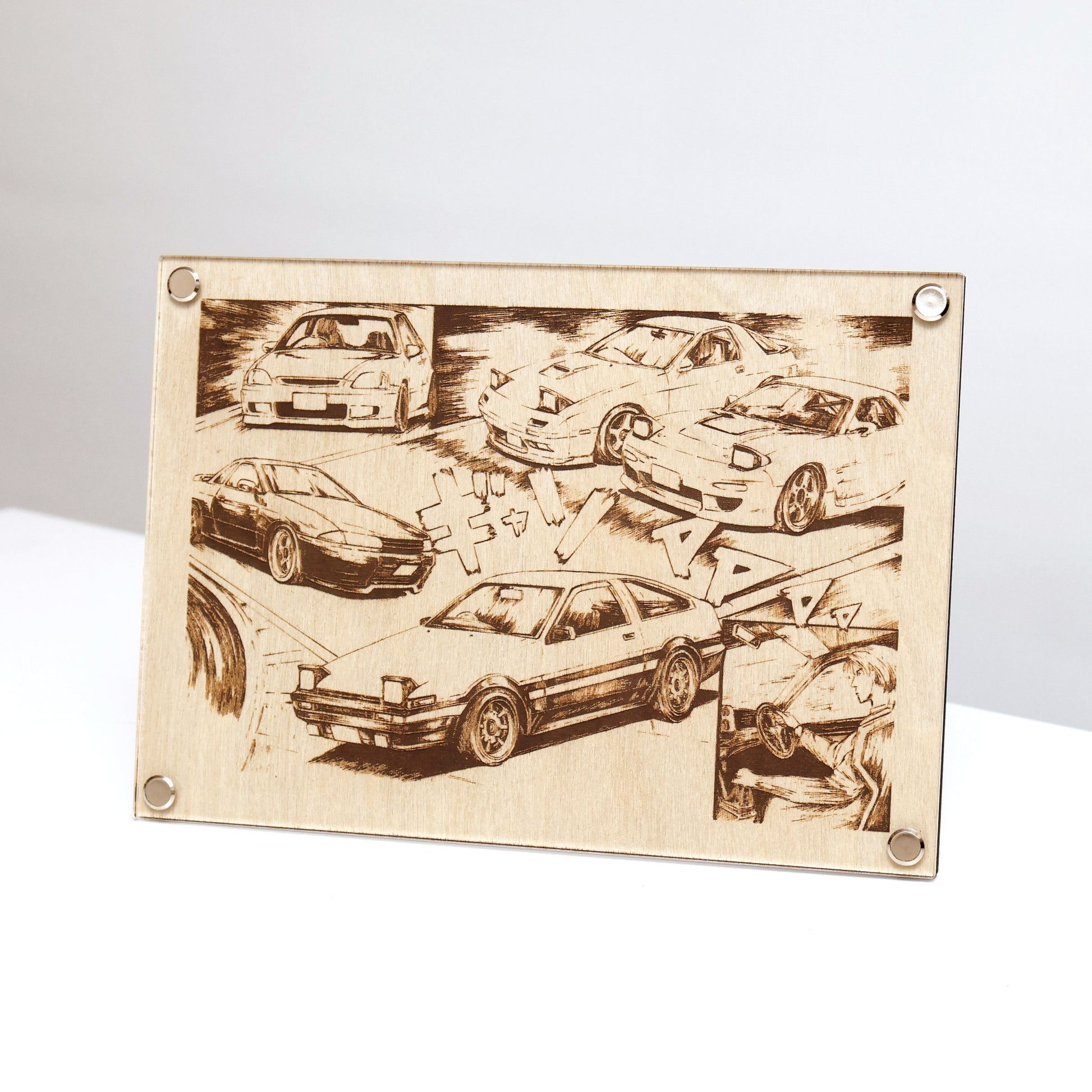 Unique wooden laser-engraved plaque inspired by Initial D. LayaBoard Art Initial D JDM Collage displayed on table with engraved images of Fujiwara’s AE86, Nakazato’s Skyline R32 GT-R, the Takahashi brothers’ RX-7s, and Shoji’s Civic. Encased in trademarked LayaBoard frame, this piece blends timeless aesthetics with a sleek, minimalist design.
