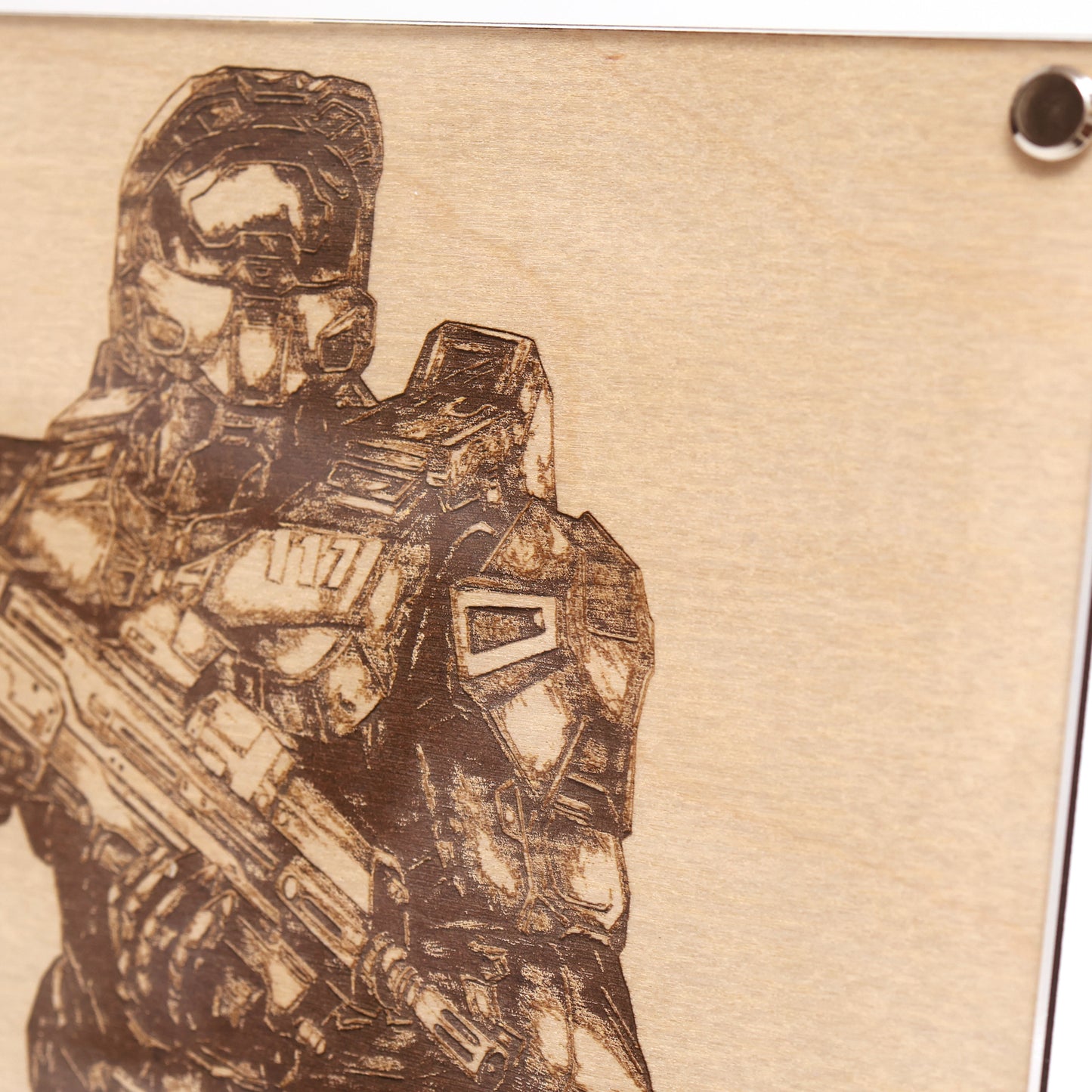Close‑up on upper right corner of engraved Halo Master Chief portrait with wood frame