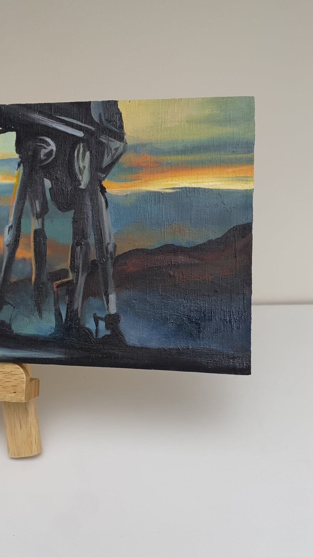 Video showing details of original oil painting on wood panel depicting silhouetted AT-AT walkers from Star Wars marching across a misty landscape at sunset. Vivid orange, yellow, and blue tones create a dramatic sci-fi atmosphere, with bold contrast and cinematic composition.