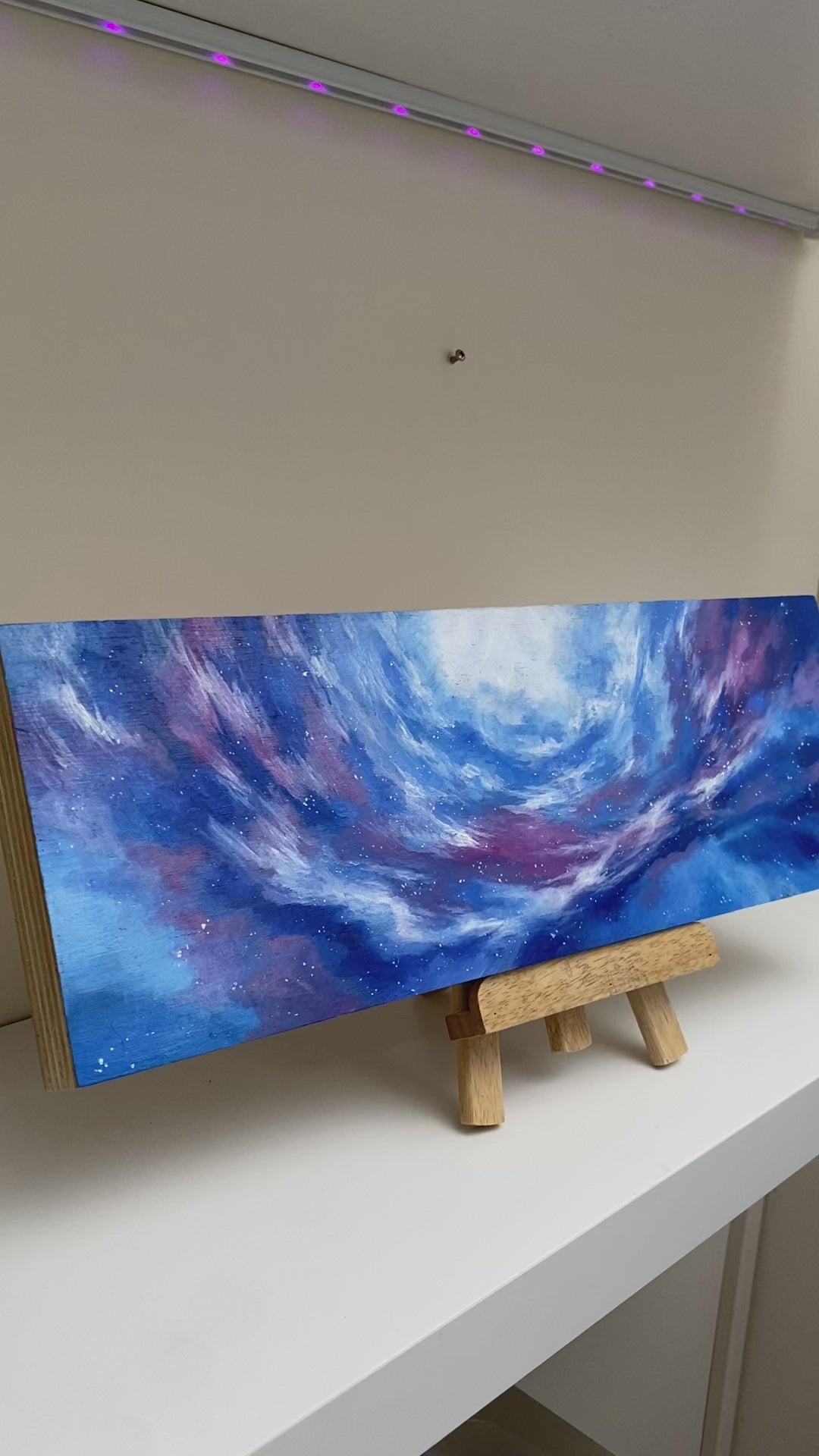 Video closeup details painting on wood panel with panoramic swirling colors of the ethereal beauty of Skyrim’s open skies and ancient echoes.