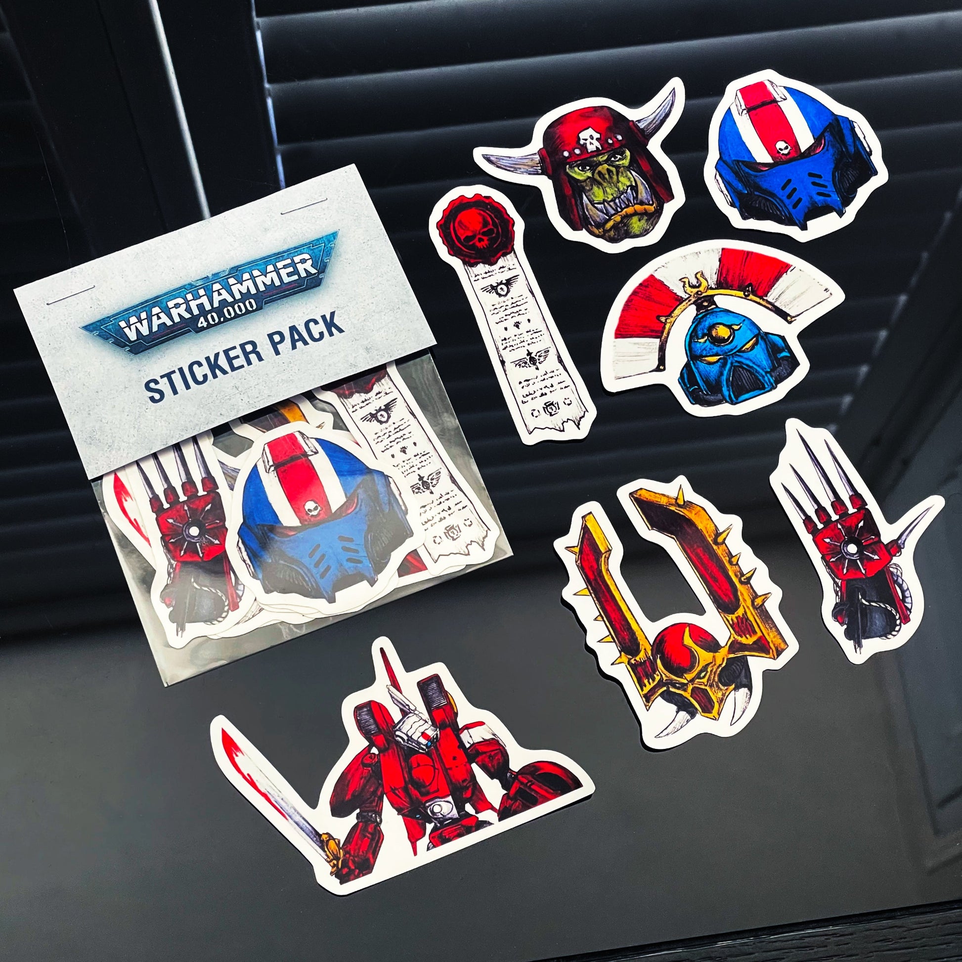 Warhammer 40,000 sticker pack with various character stickers on a dark surface.